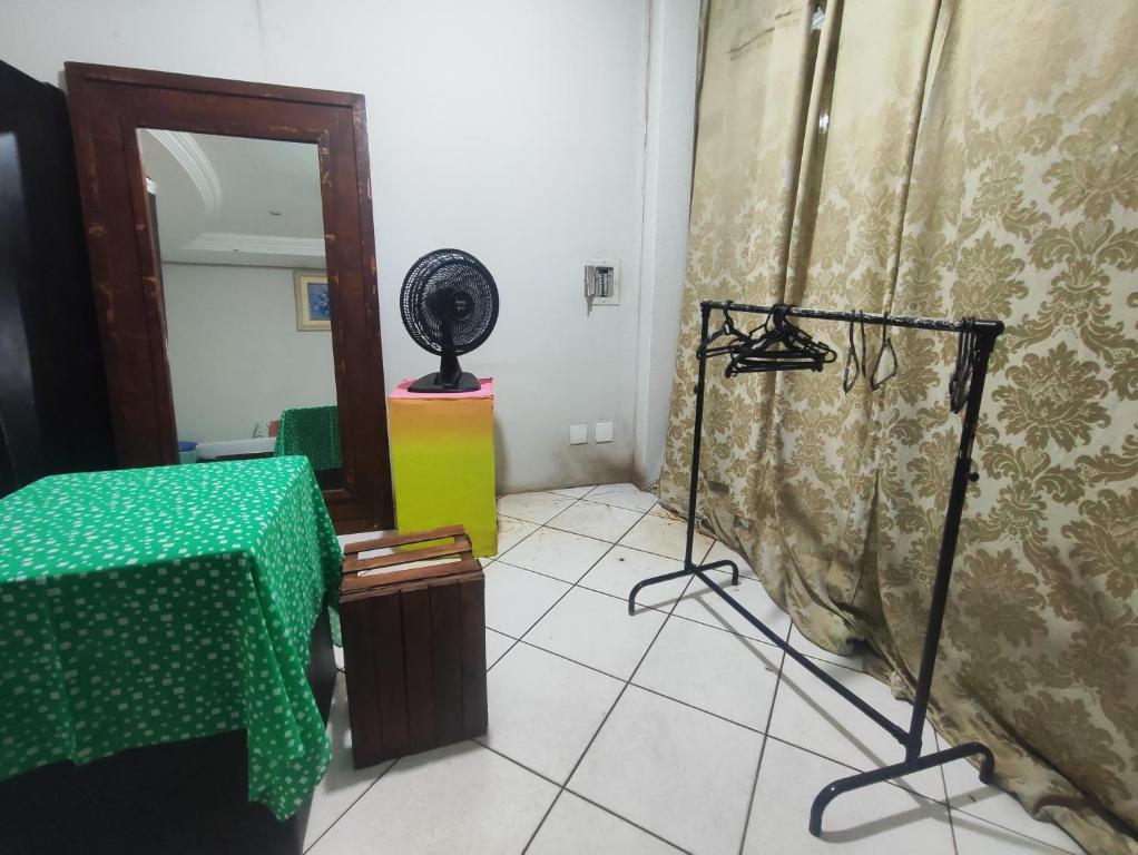 a room with a table and a fan in it at Pousada Nova Jerusalém in Cianorte