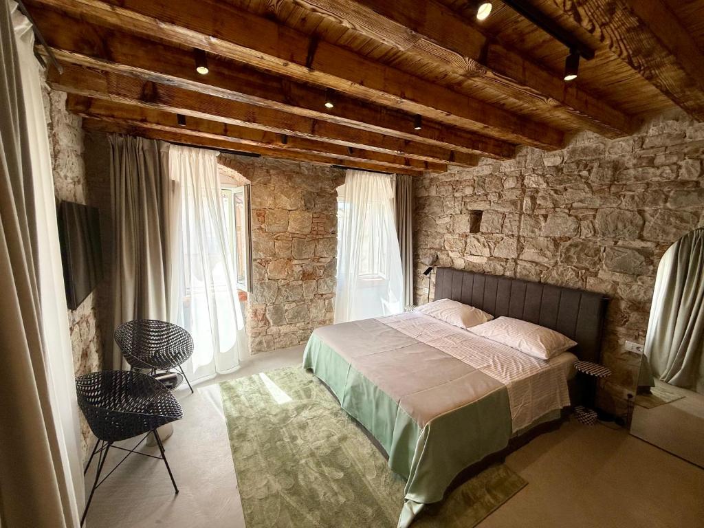 a bedroom with a bed and a stone wall at Piazza room in Split