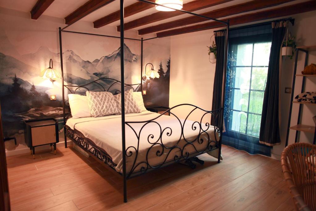 una camera da letto con un letto con baldacchino di metallo di Appartement romantique à 5mn de la cathédrale d'Albi ad Albi