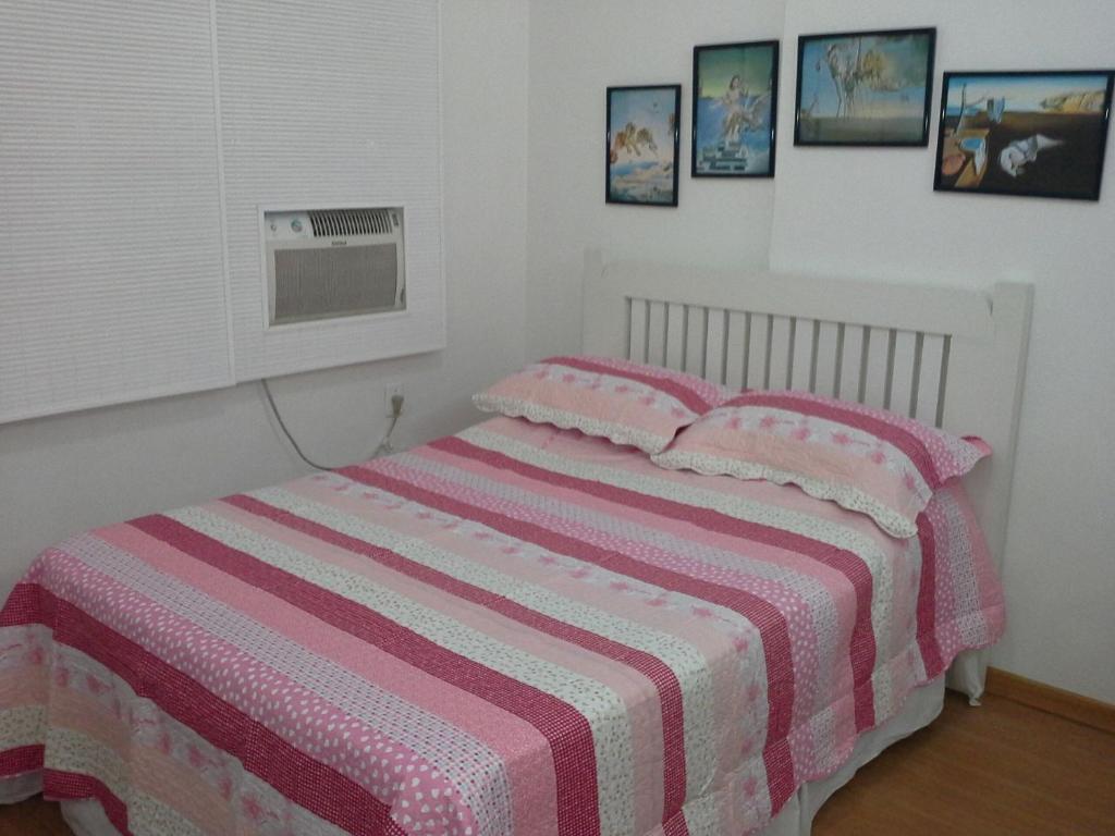 een slaapkamer met een bed met een roze en wit gestreepte deken bij Studio em Copacabana in Rio de Janeiro