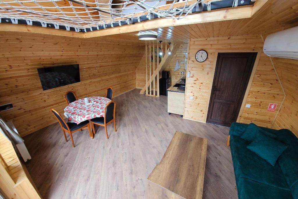 une chambre avec une table, des chaises et une horloge dans l'établissement Kolkheti Eco Cottages livlivi ლივლივი - small cottage, à Poti