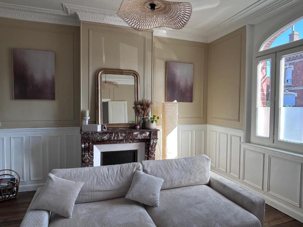 a living room with a couch and a mirror at Maison chic et cosy in Roye