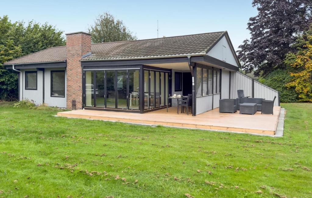 a house with a deck with a table and chairs at 3 Bedroom Stunning Home In Grenaa in Grenå