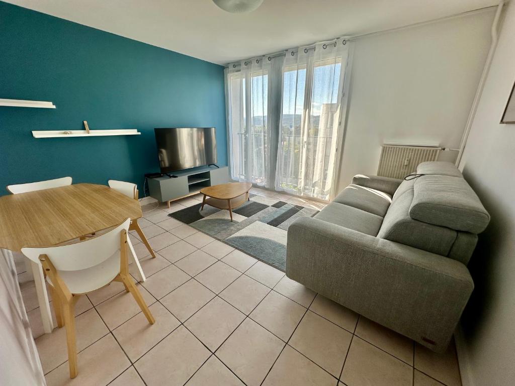 a living room with a couch and a table at Grand et Bel appartement 6 personnes in Valence