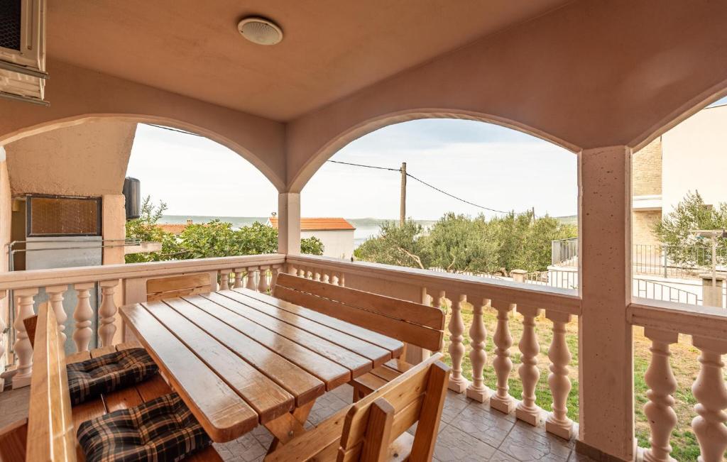 a porch with a wooden bench on a balcony at Lovely Apartment In Maslenica With House Sea View in Šarić