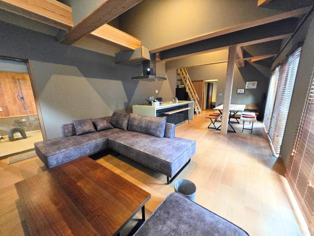 a living room with a couch and a table at Relaxing箱根彫刻の森ーサウナ付き一棟貸しの宿 in Hakone