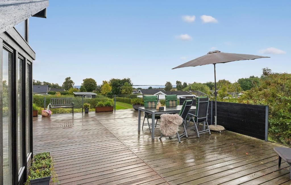 una terraza con mesa, sillas y sombrilla en 2 Bedroom Nice Home In Hejls, en Hejlsminde