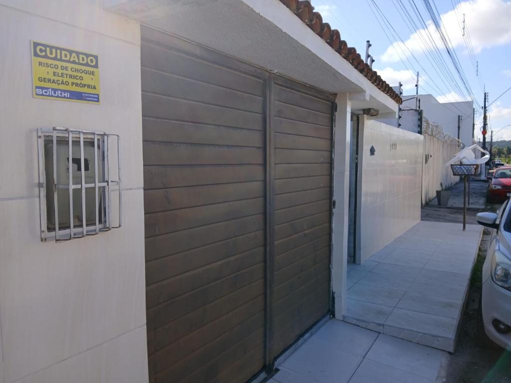 una puerta de madera de garaje en el lateral de una casa en Casa temporada 3 quartos Barra nova C, en Marechal Deodoro