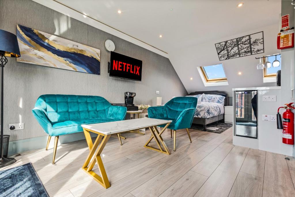 a living room with a table and chairs and a bed at Imperial Inn Studios in London