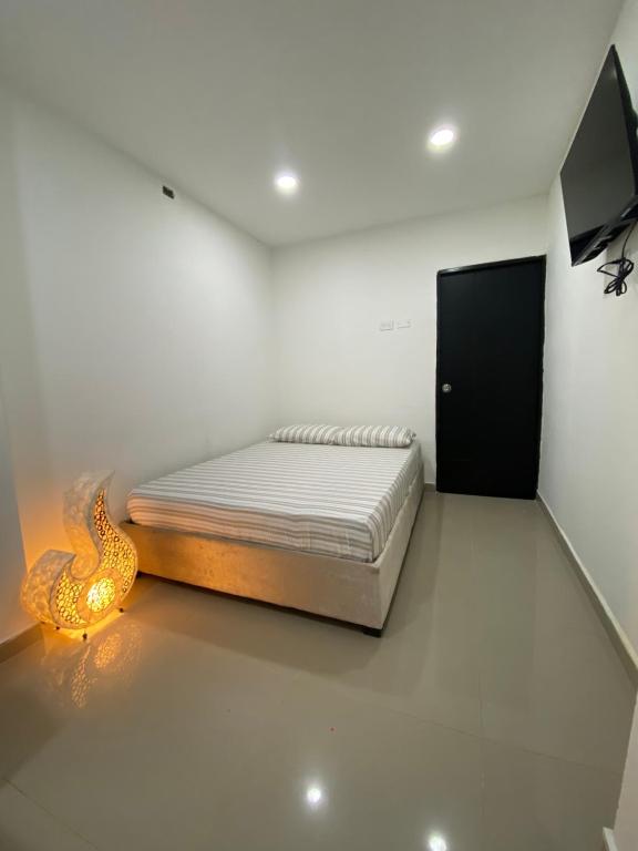 カルタヘナ・デ・インディアスにあるHabitación Privada en La Boquillaのベッドと薄型テレビのある寝室
