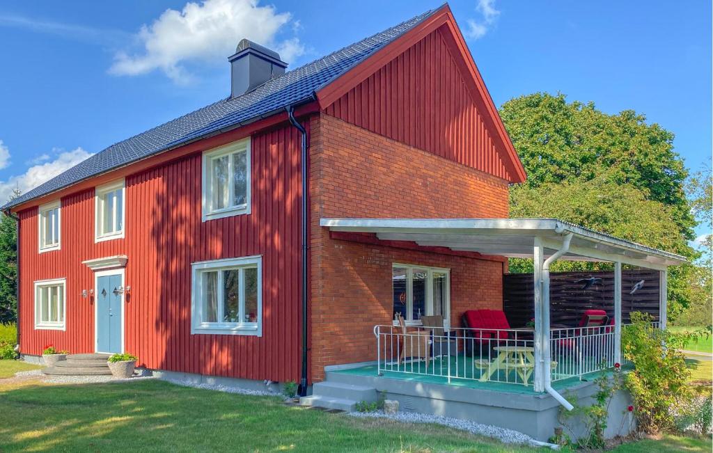 a red barn with a porch and a patio at 1 Bedroom Amazing Home In Jät in Jät
