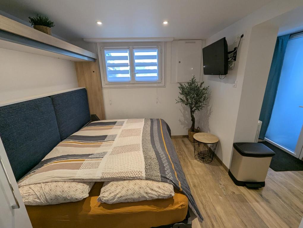 Un dormitorio con una cama y un televisor. en Studio aux portes du Puy duFou, en Les Herbiers