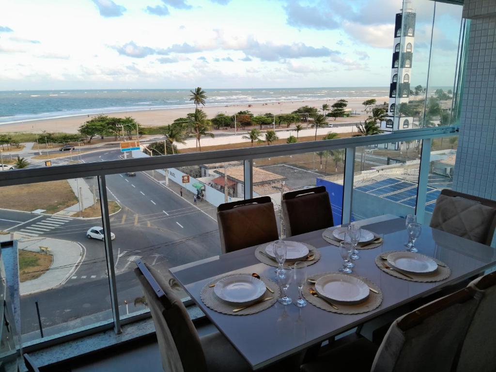 a table with wine glasses and a view of the beach at Apartamento Vista Mar atalaia varanda gourmet in Aracaju