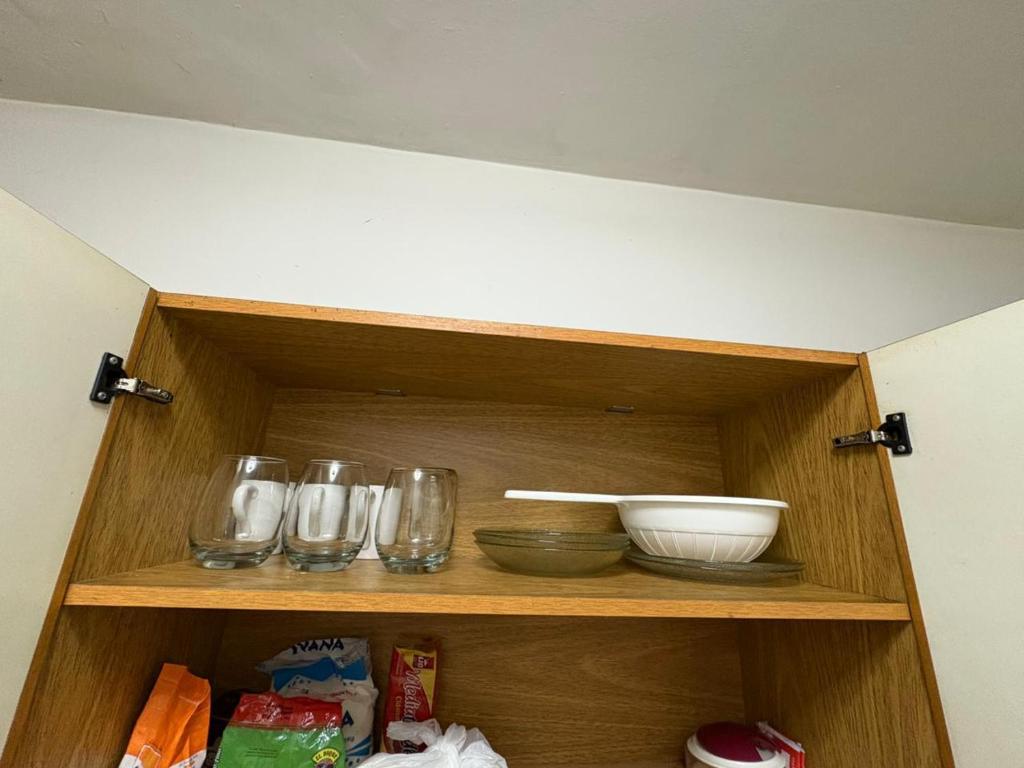une armoire en bois avec des bols et des verres dessus dans l'établissement hermoso departamento centrico a 1 cuadra de plaza principal, à San Miguel de Tucumán