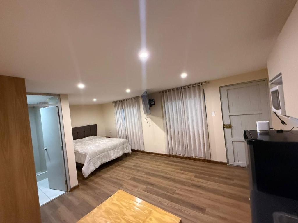 アレキパにあるVallecito Downtown Roomsのベッドルーム1室(ベッド1台付)、テーブル付きのベッドルーム1室が備わります。
