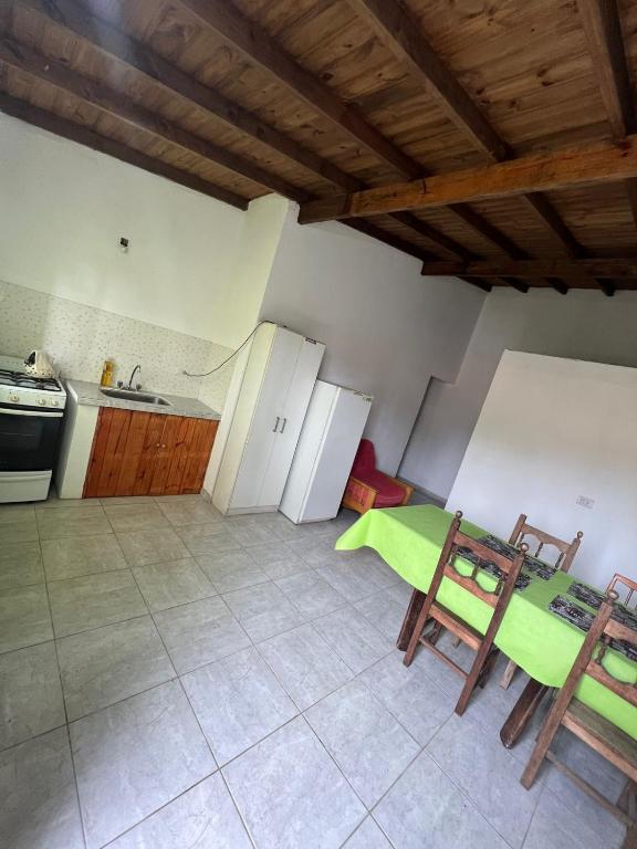 eine Küche mit einem grünen Tisch und Stühlen darin in der Unterkunft Cabañas del Sur in Mar del Plata