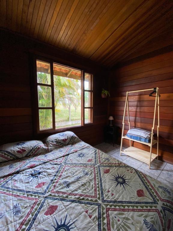 a bedroom with a bed and a window at QUARTO Outono em Casa de Madeira no Alto da Serra - PetFriendly in São Roque
