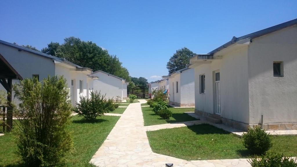 a row of buildings with trees in the yard at Beni Bungalows in Ulcinj