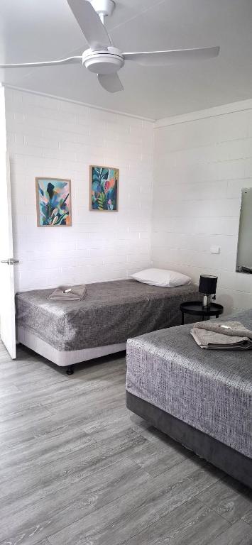 a bedroom with two beds and a ceiling at Burdekin Motor Inn in Home Hill