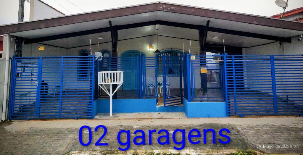 a blue gate in front of a building at Casa Dna Nair Gus in Ubatuba