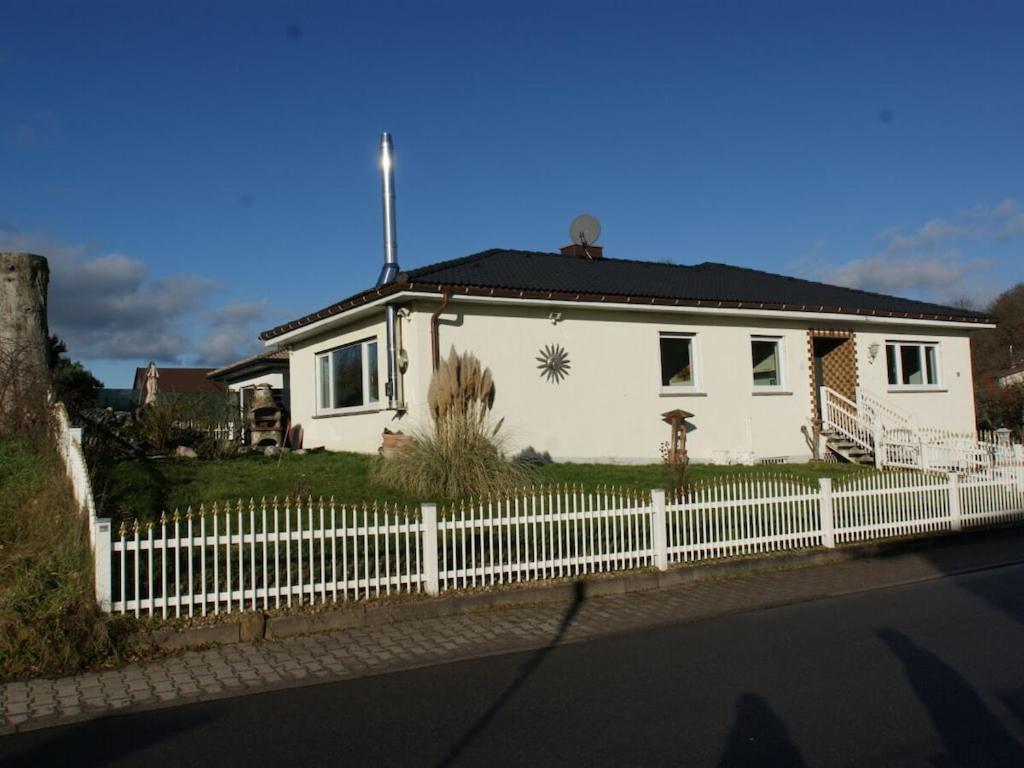 a white house with a white picket fence at Holiday home in Erbach with swimming pool in Dorf Erbach