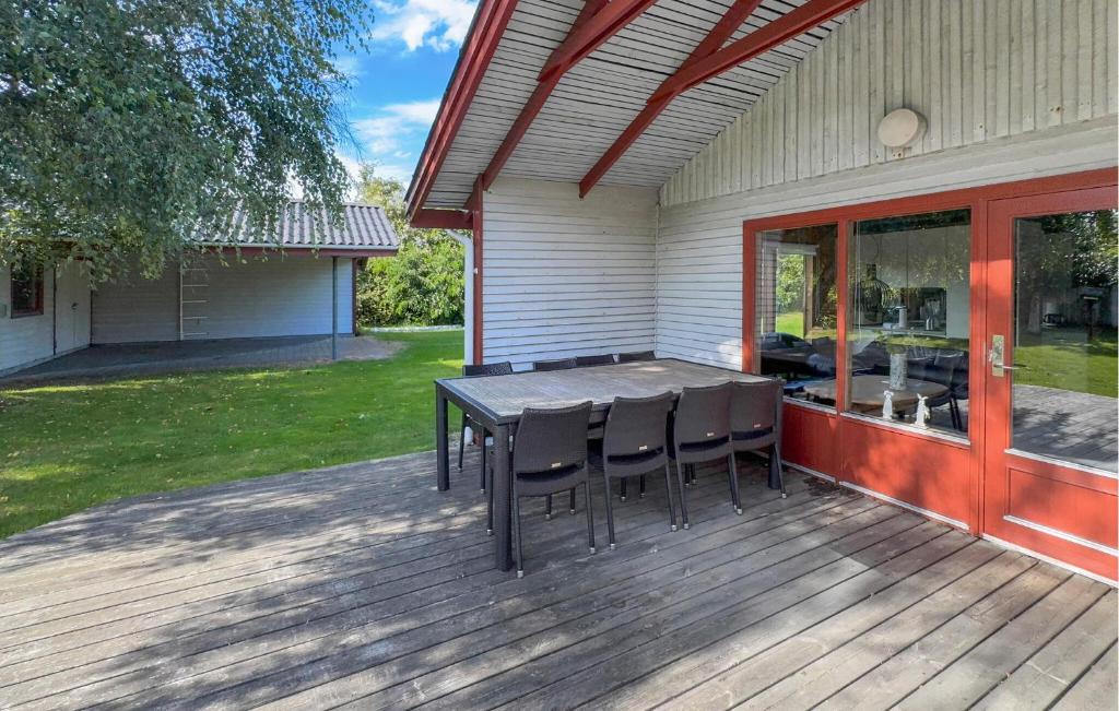 a wooden deck with a table and chairs on a house at Stunning Home In Tarm With Sauna in Højsand
