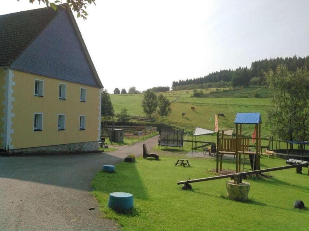 a building with a playground in a field at One-bedroom apartment in Cobbenrode