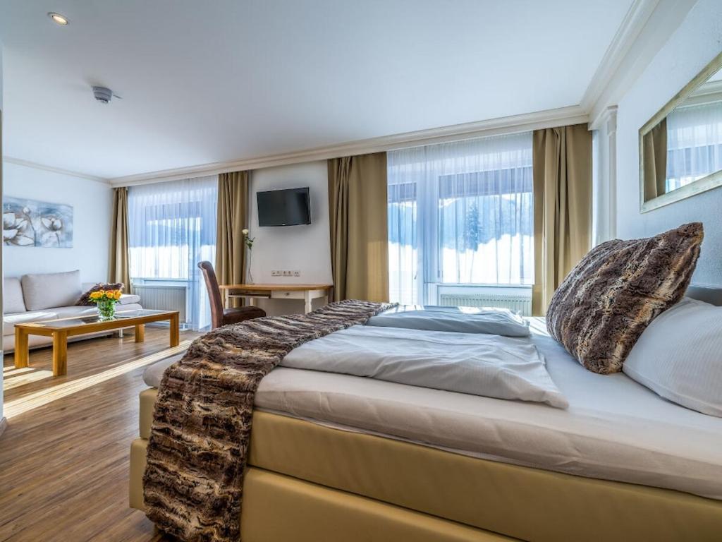ein Schlafzimmer mit großem Bett und ein Wohnzimmer in der Unterkunft Holiday apartment with 2 bedrooms in Kalzhofen