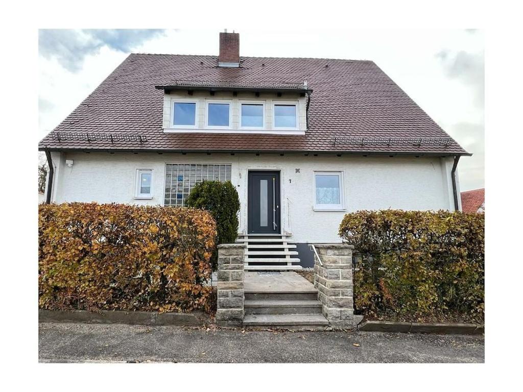 a white house with a black door and stairs at Holiday home with 2 bedrooms in Schopfloch