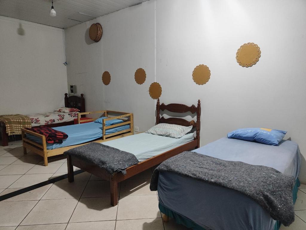 a room with two beds and a chair in it at Pousada Nova Jerusalém in Cianorte