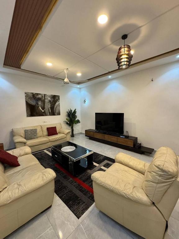a living room with couches and a flat screen tv at Kwamba in Cotonou