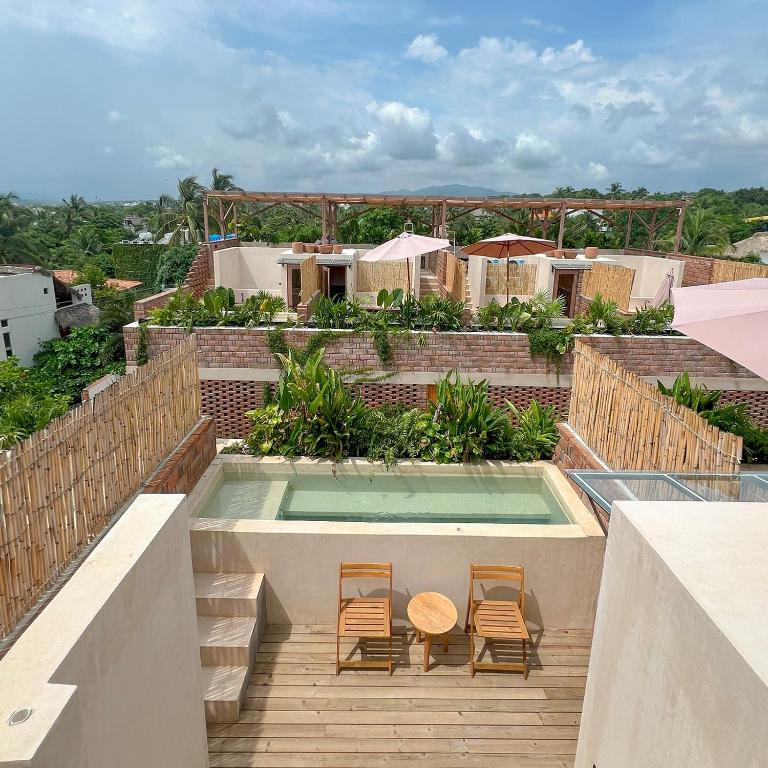 a balcony with two chairs and a swimming pool at Casa Xaviera in Puerto Escondido