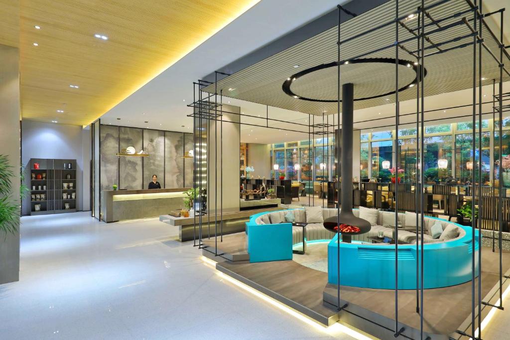 a lobby of a building with a glass wall at 唐人酒店上海虹桥火车站国家会展中心店 in Fangjiayao