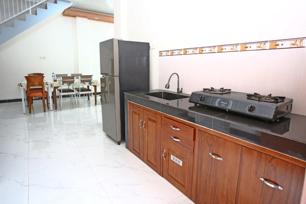 a kitchen with a sink and a stove at Mentari Homestay in Sentool