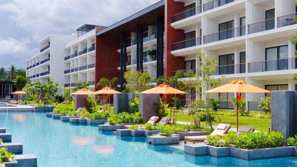 an image of a hotel swimming pool with umbrellas at Sunshine Prestige Resort and Spa in Cha Am