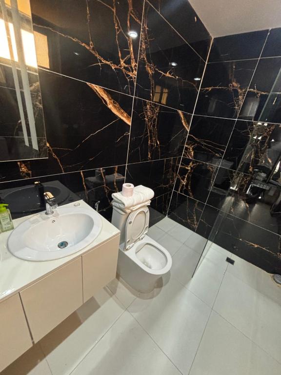ダカールにあるResidence DIBAの白いトイレと洗面台のあるバスルーム
