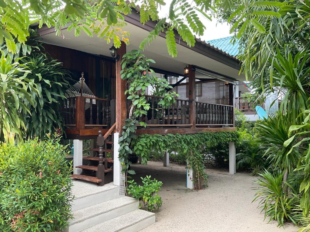 una casa con un balcone e scale in un giardino di Boutique Beach Cottage - Steps to Beach a Nathon Bay