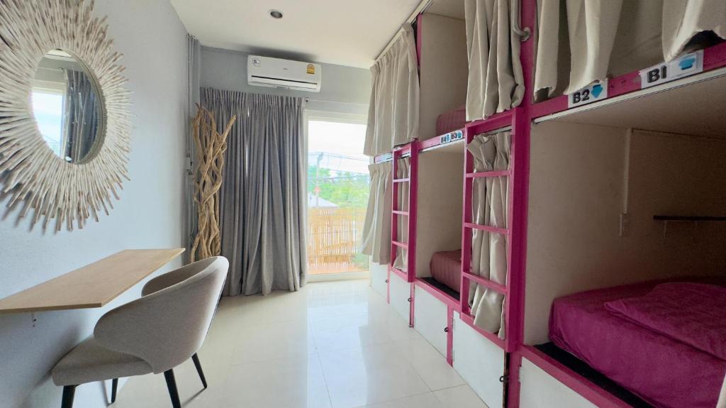 une chambre avec des lits superposés, une table et des chaises dans l'établissement Arena Boutique Hotel Female only, à Thongsala