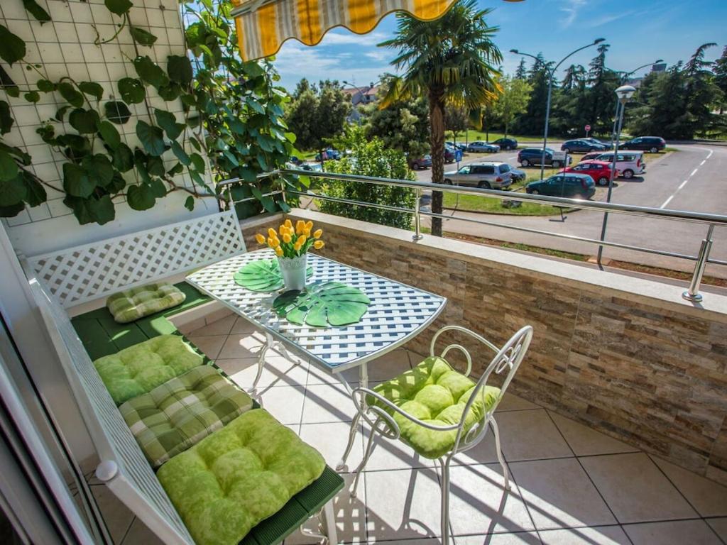 a balcony with a table and chairs and a view of a street at Apartment with 2 bedrooms in Poreč