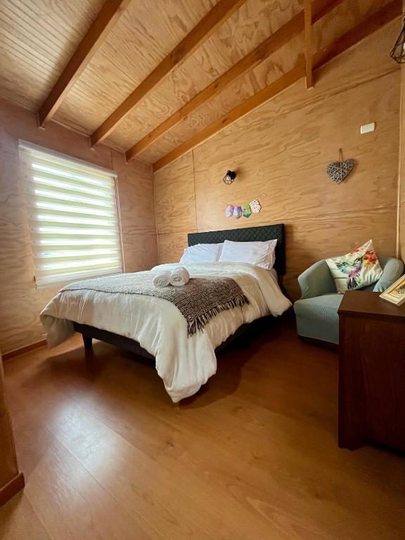 a bedroom with a bed and a couch in a room at Departamentos NuBe1 Castro Chiloé in Castro