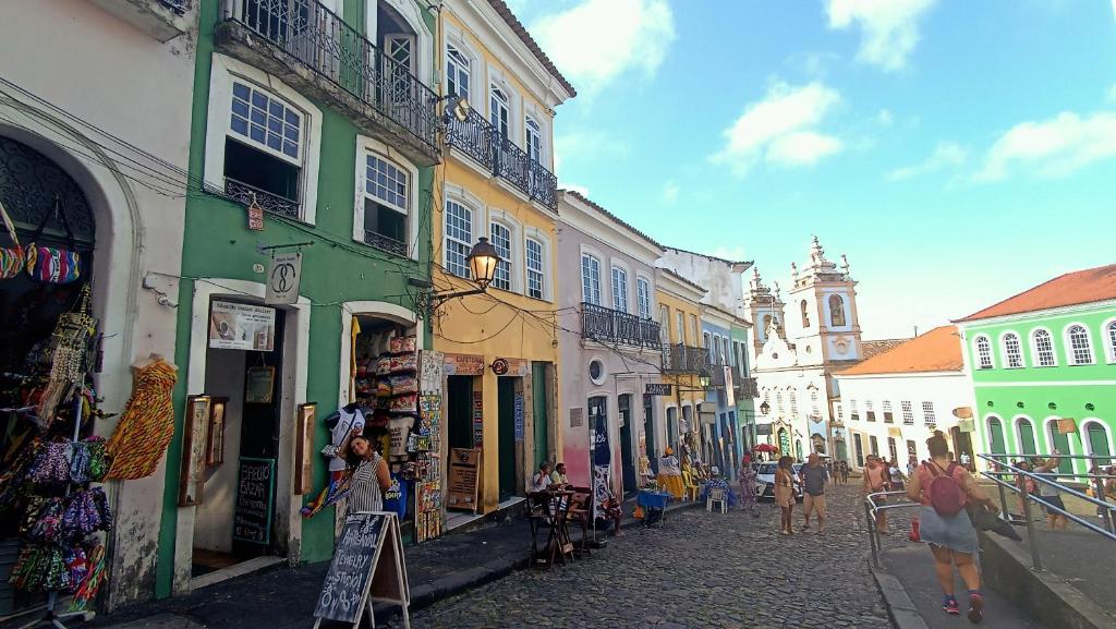 a group of people walking down a street with buildings at Pelourinho House Experience in Salvador