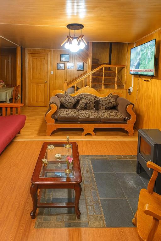 a living room with a couch and a coffee table at Hospedaje de la Abu in Coihaique
