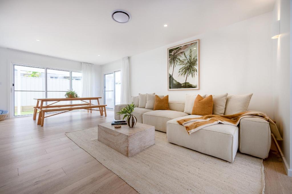a white living room with a couch and a table at Olas Villa 5 - Plunge Pool & Walk to Beach in Anna Bay