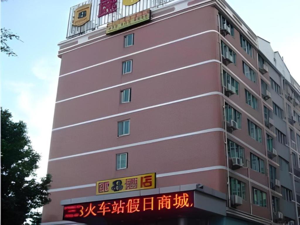 a pink building with writing on the side of it at Super 8 Hotel Xiamen Train Station Holiday Mall Branch in Xiamen