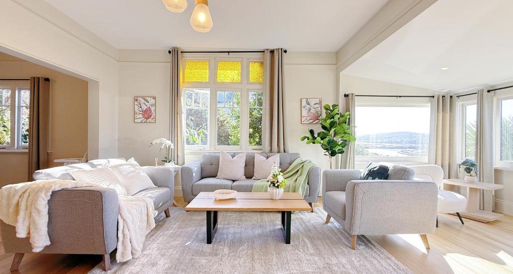 a living room with two couches and a table at StayAU 2BR Home with Stunning Views in Tasmania in Inveresk