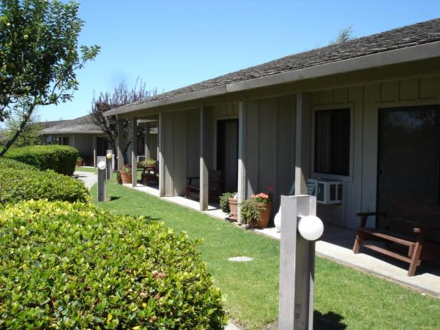 a house with a bench in front of a yard at Ridgemark Golf Club and Resort in Hollister