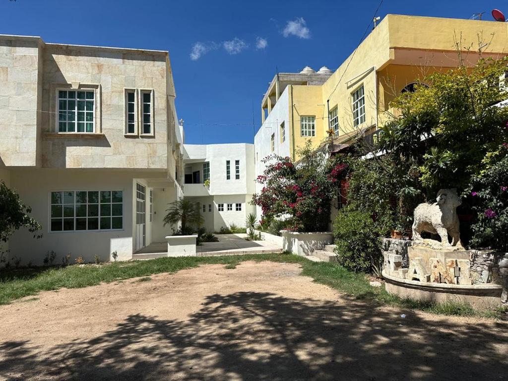 a building with a statue of a goat in a yard at Hotel Leilani in San Andrés Sinaxtla
