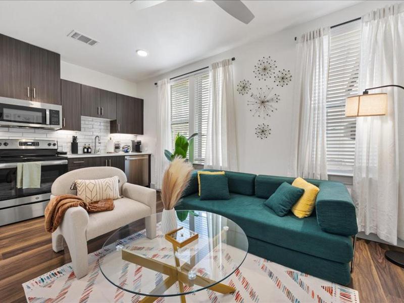 a living room with a green couch and a glass table at Peaceful Hideaway with Pool, Gym & EV charger in Addison