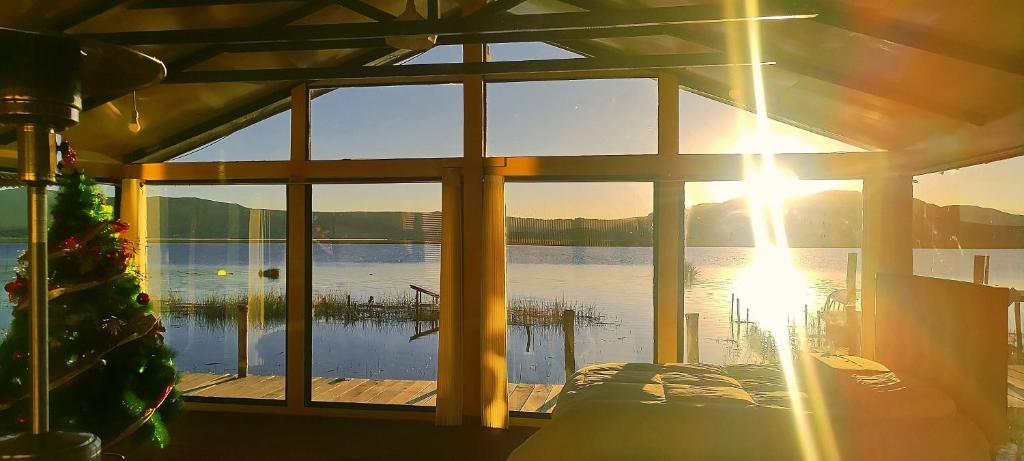 a view of a lake from a house with a christmas tree at Uros kantuta Lodge in Puno