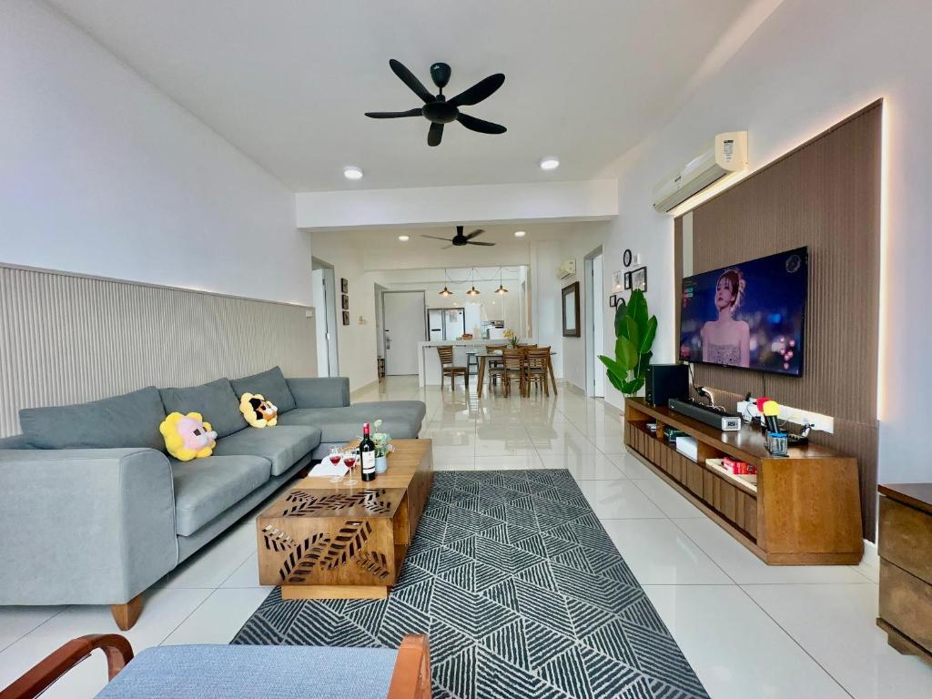 un salon avec un canapé et une télévision dans l'établissement New Reno Jazz Suite 2 bedroomsSeaviewKaraoke, à Tanjong Tokong
